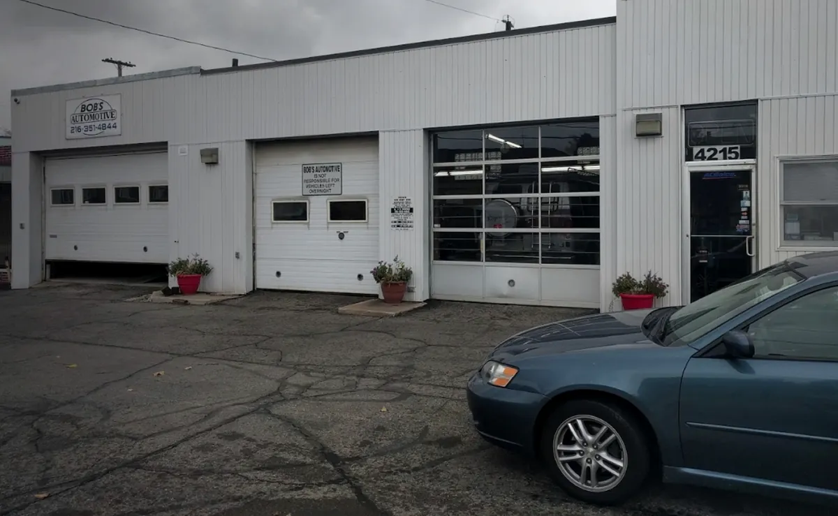 Bob’s Automotive on Ridge Road: white siding, three service bays, flowerpots and office door 4215.